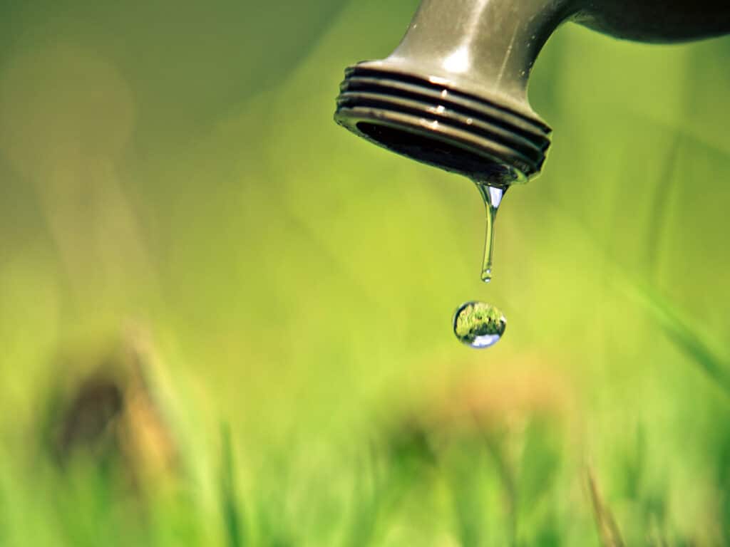 Outdoor water faucet dripping water in fall